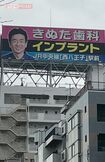 幹線道路・高速道路など、都内の至るところにある、院長の顔写真入り『きぬた歯科』の看板(東京・杉並区)
